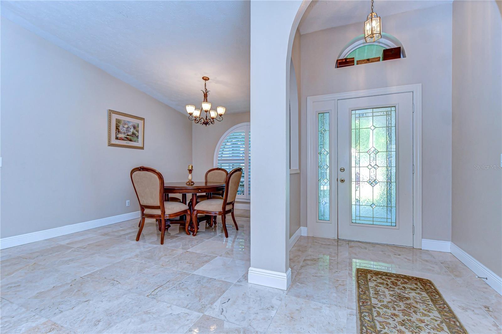 Step into elegance with this inviting entryway, where light dances across the pristine floors.