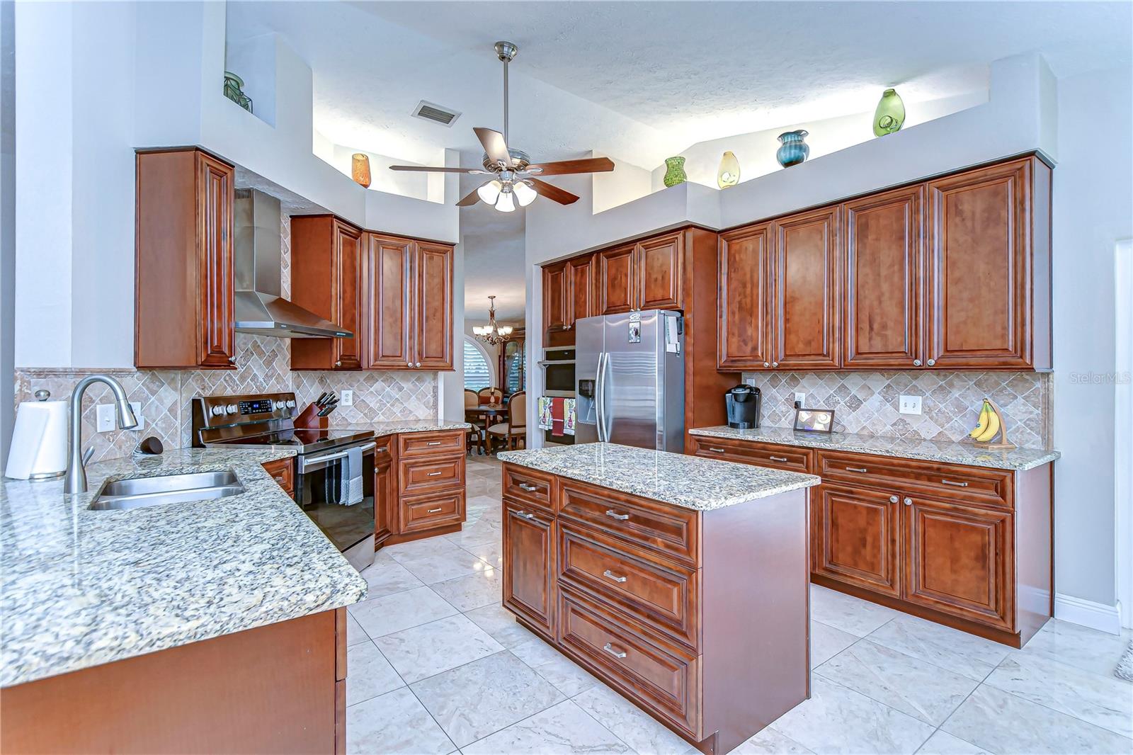 This kitchen boasts elegant granite countertops and rich wooden cabinetry, perfect for hosting