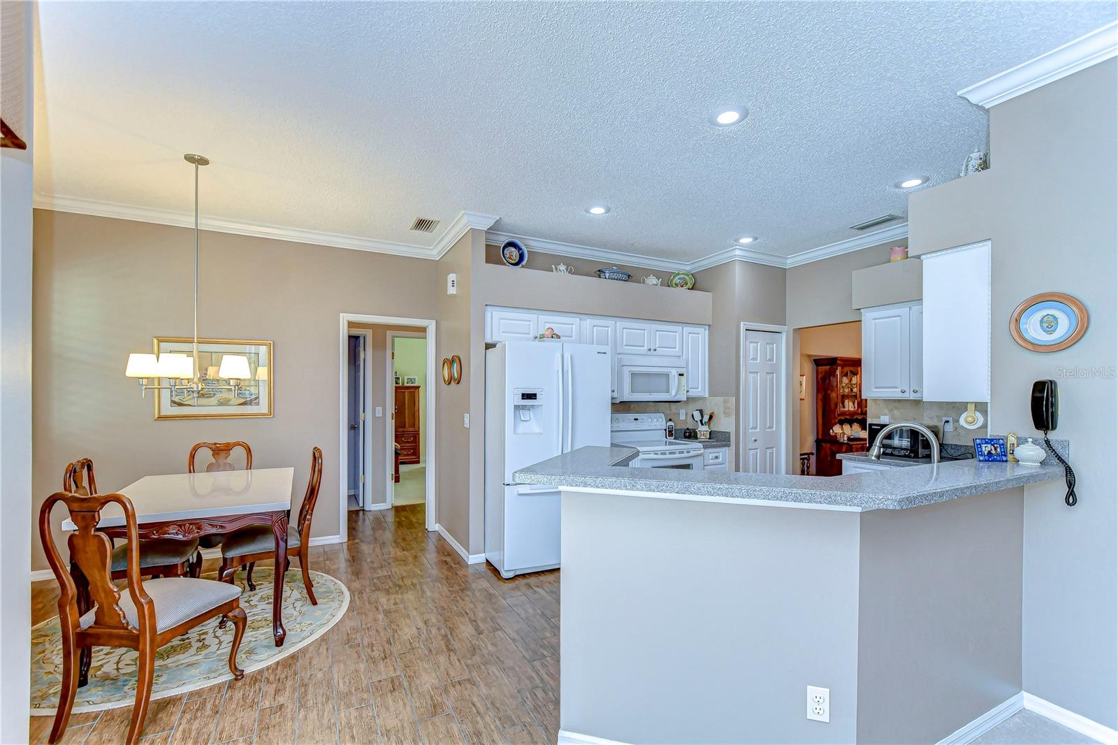 Discover a harmonious blend of comfort and style in this inviting kitchen and dining area, where warm tones and elegant finishes create the perfect setting for memorable meals and gatherings. The