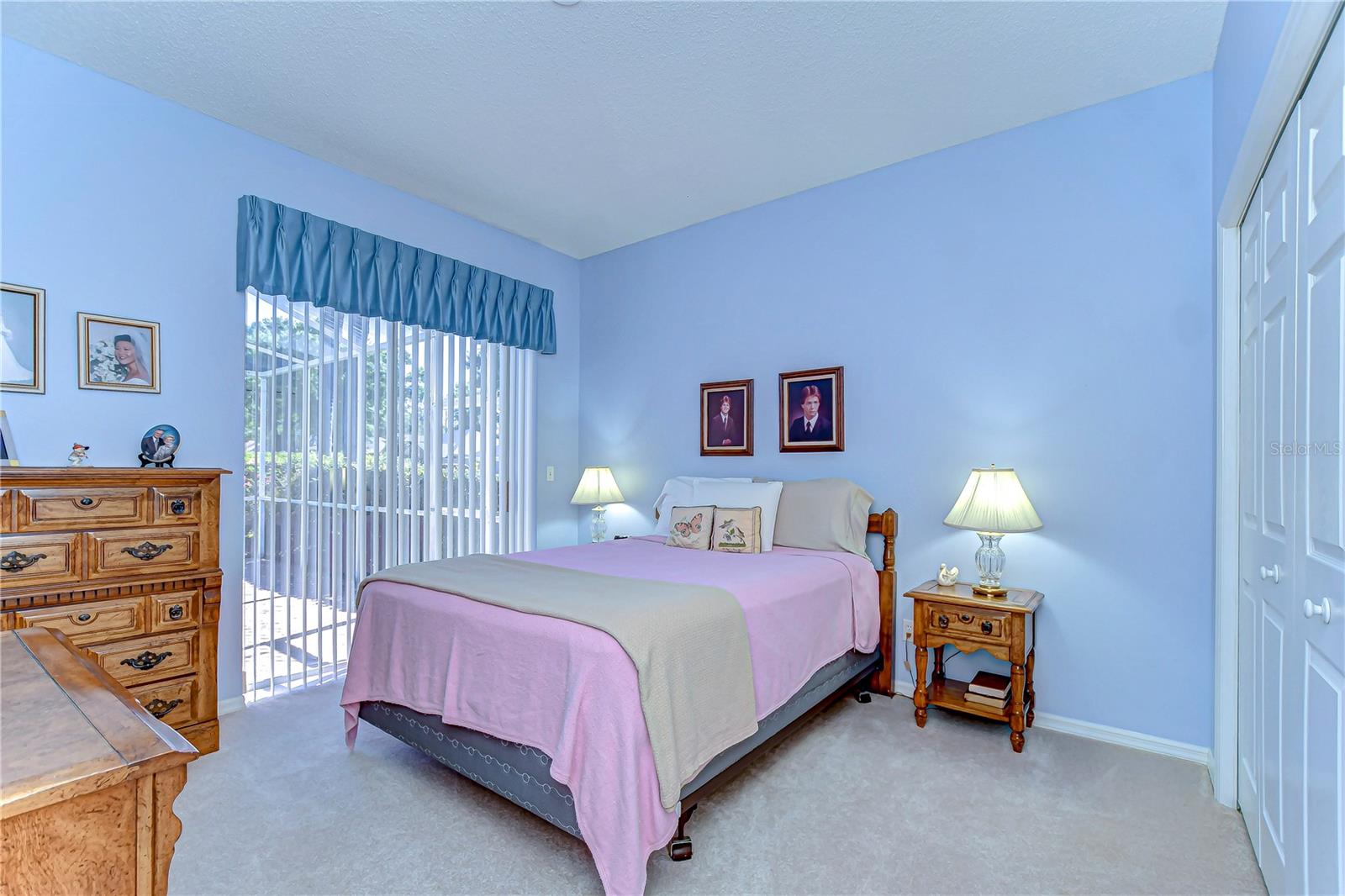 Awash with natural light streaming through large sliding doors, the bedroom feels wide open and welcoming.