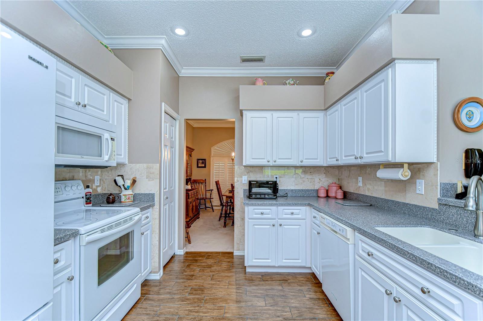 The gleaming countertops and pristine white cabinetry create a bright, airy ambiance