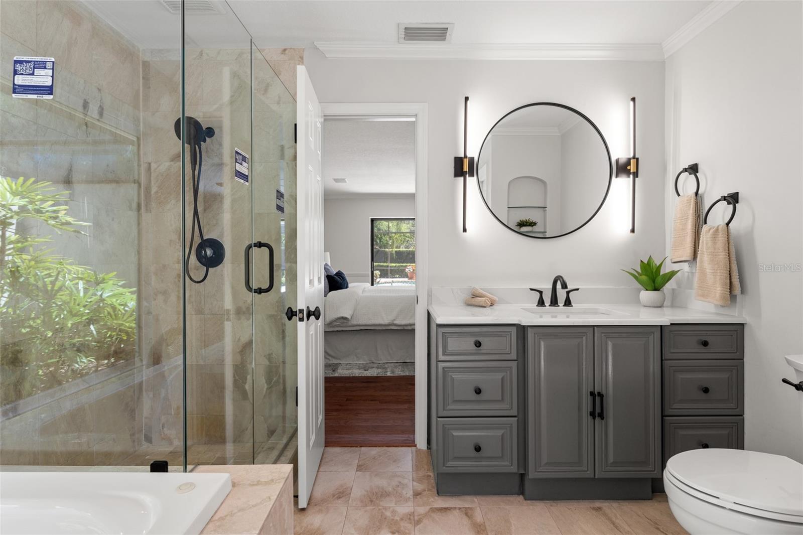 Renovated Primary Bath with NEW LED Lighting, NEW Glass-Enclosed Shower, NEW Matte-Black Hardware, NEW Vanity, and NEW Toilet.