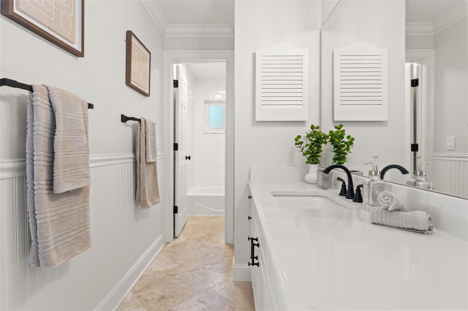 Renovated New Bath, Oversized Gold Calcutta Quartz Counters and Travertine Flooring