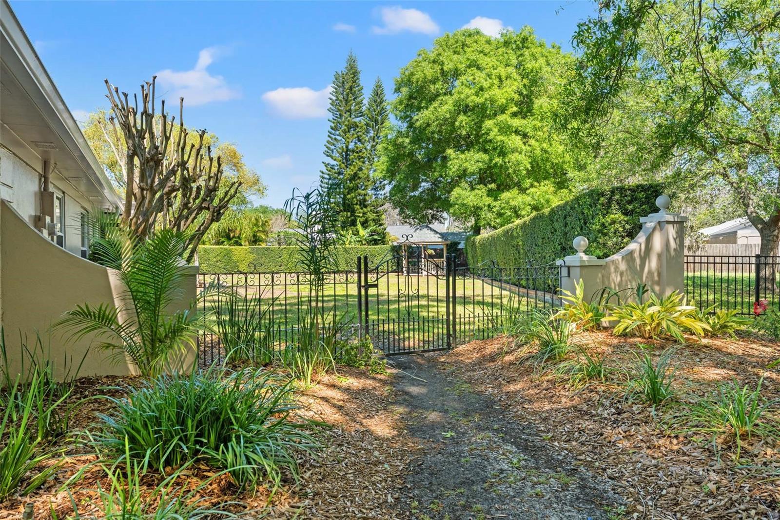 Masonry Walls and Wrought Iron Gates Adorn the Eastern Border of the Property