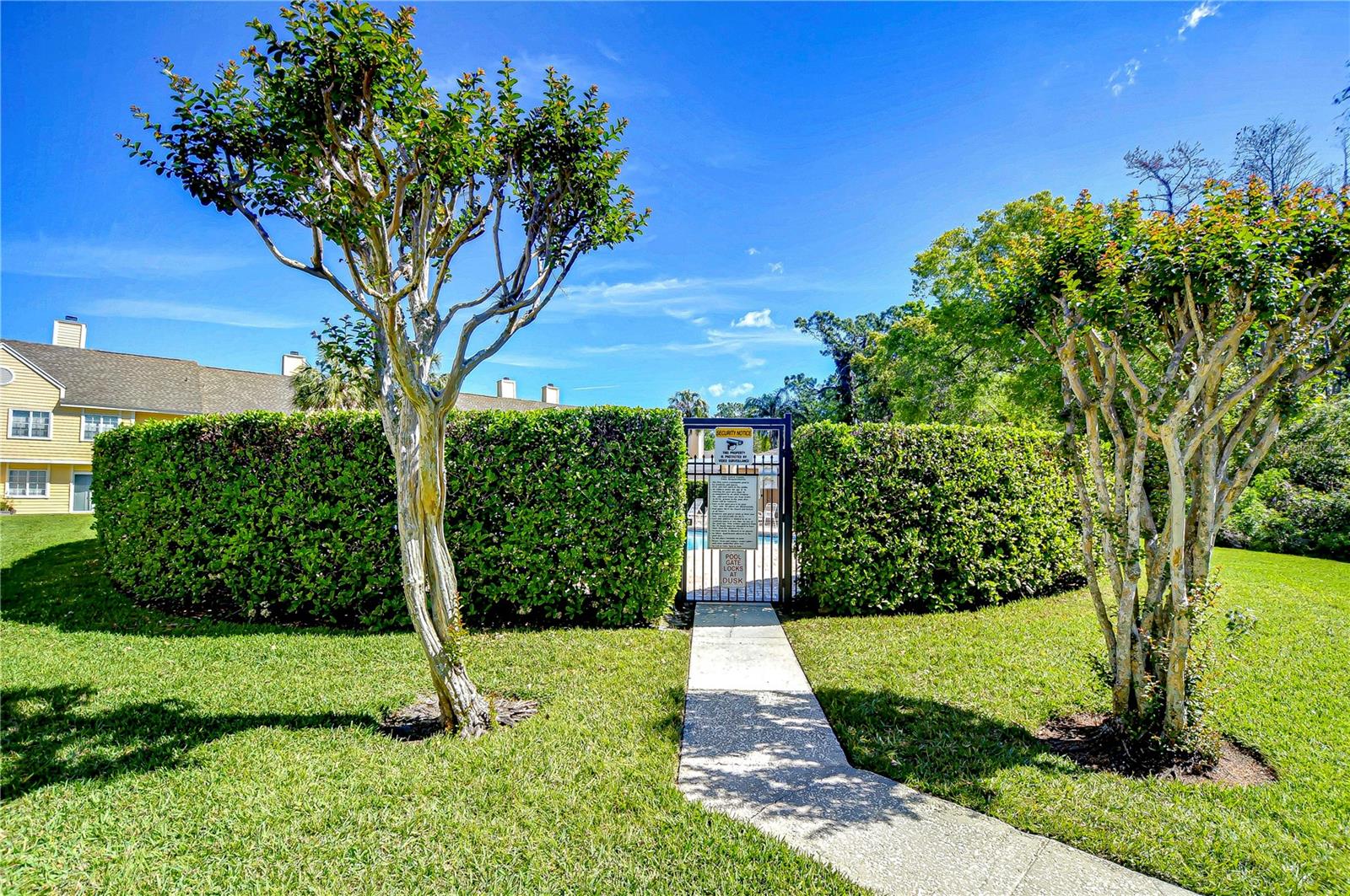 Community pool entrance is perfectly landscaped!