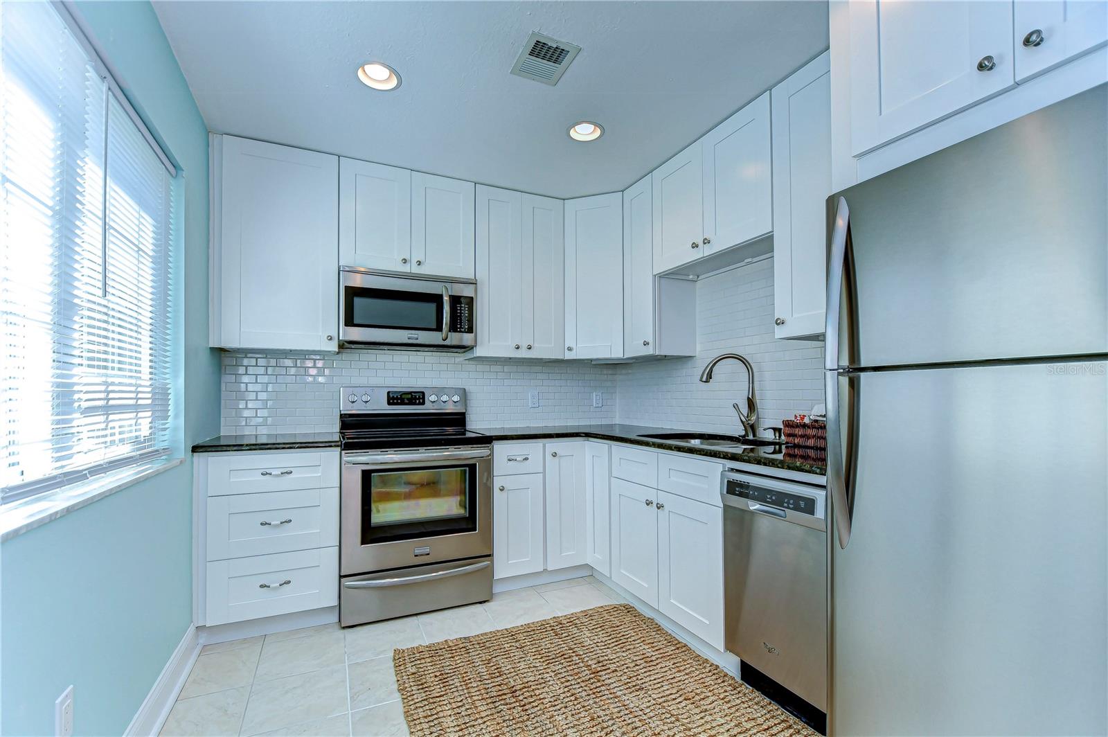 Prepare to impress in this stylish kitchen, where sleek stainless steel appliances meet classic white cabinetry.