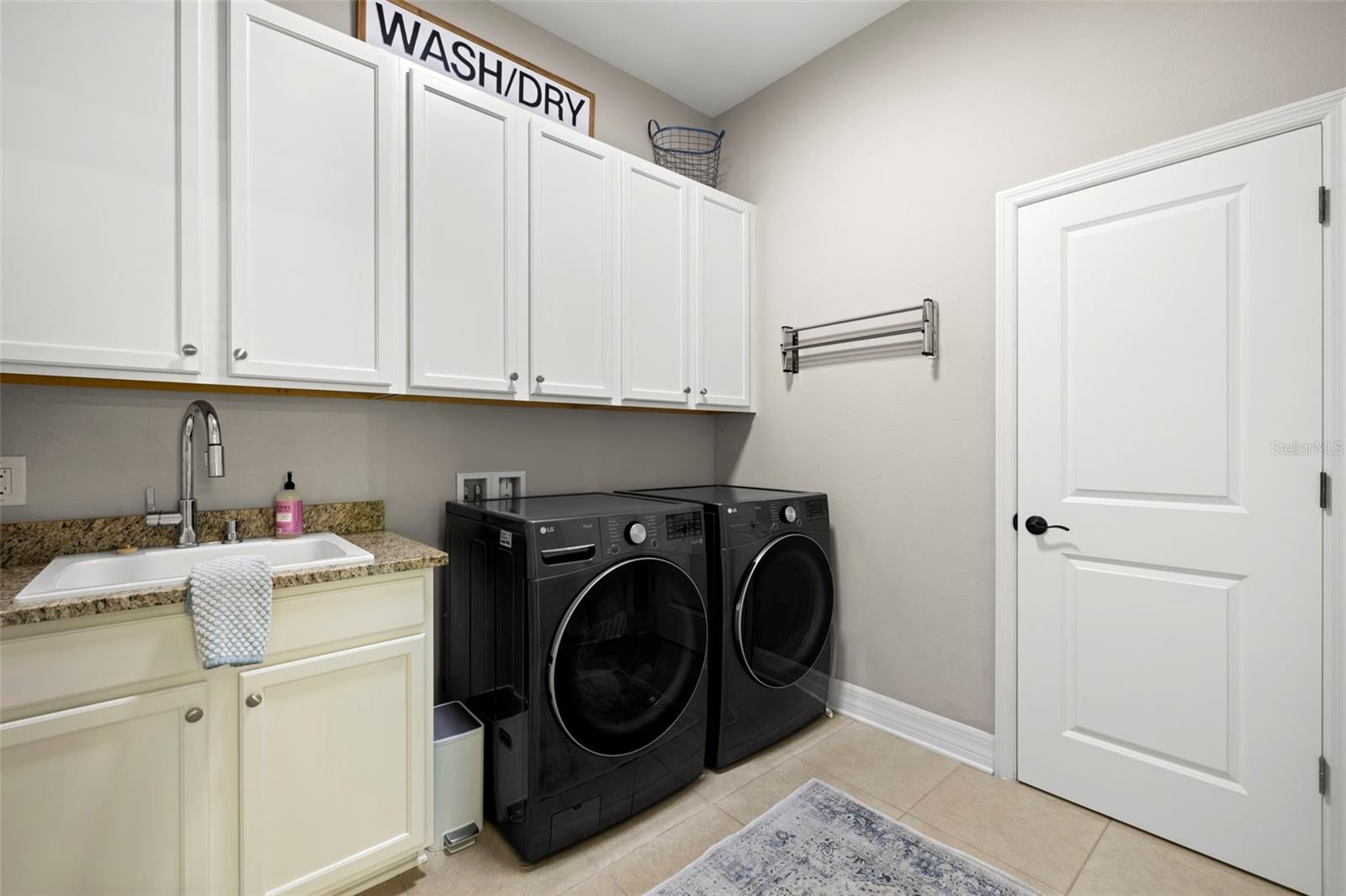 LARGE LAUNDRY ROOM W/ OVERHEAD CABINETS, LAUNDRY SINK W/STORAGE, STORAGE CLOSET & UNDER STAIRS STORAGE