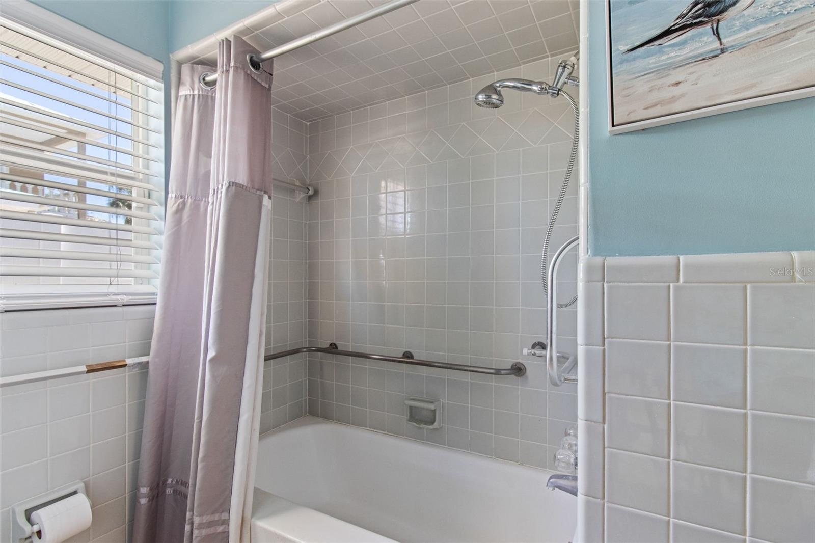 The guest bathroom has a tub with a shower