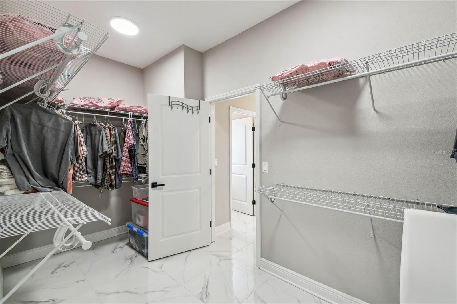 primary closet with exit to laundry room