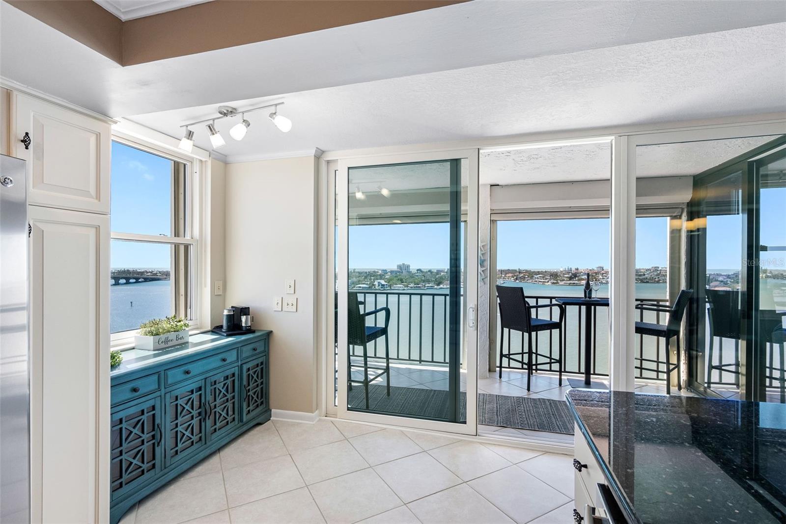 Spacious living room with floor-to-ceiling impact windows showcasing endless water views.