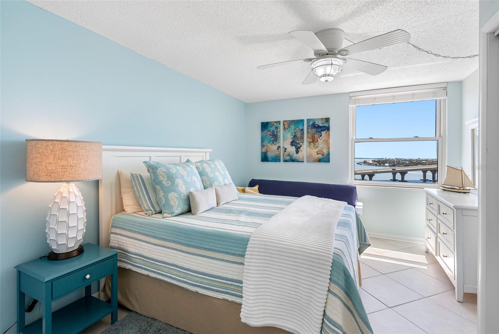 Generously sized guest room with built-in shelving, double closets, and expansive water views.