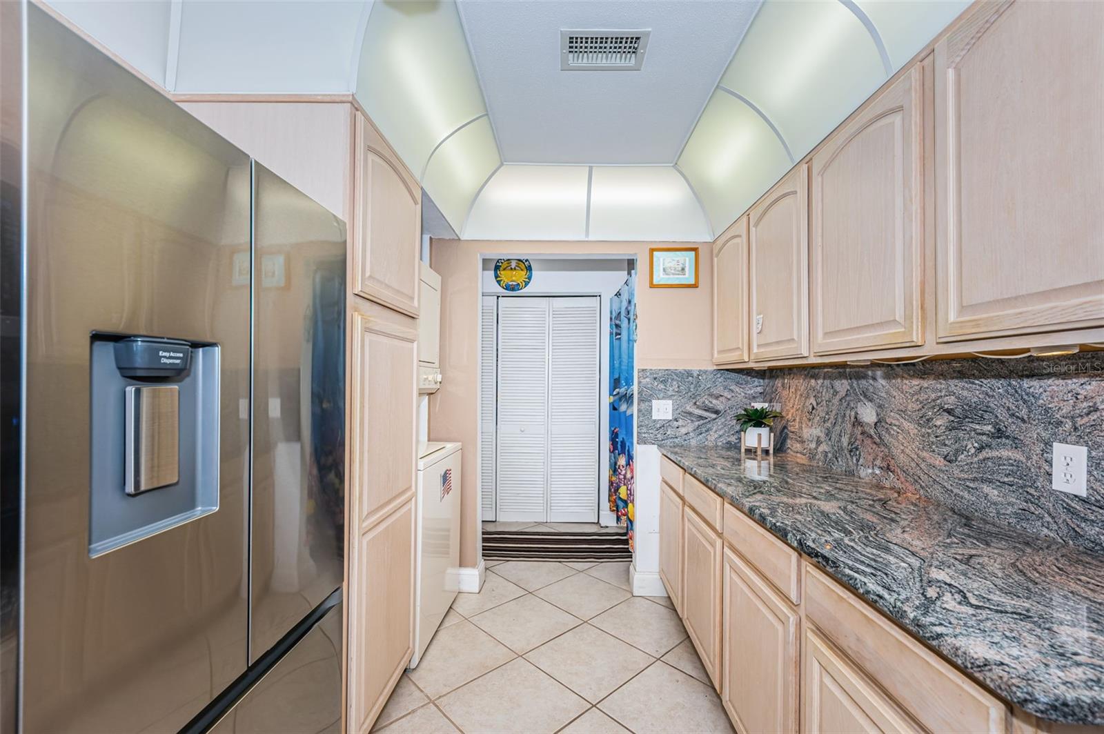 Kitchen picture looking towards entry hall, lots of counter space and cabinetry