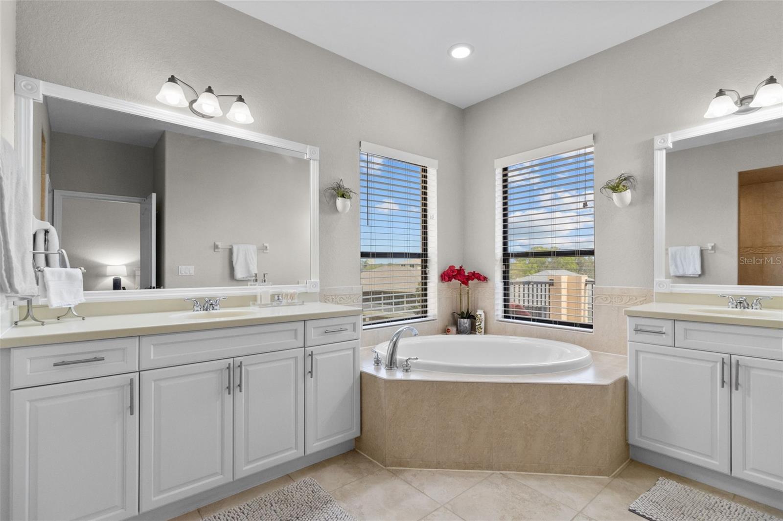 Primary bathroom with jetted tub, two separate vanities.