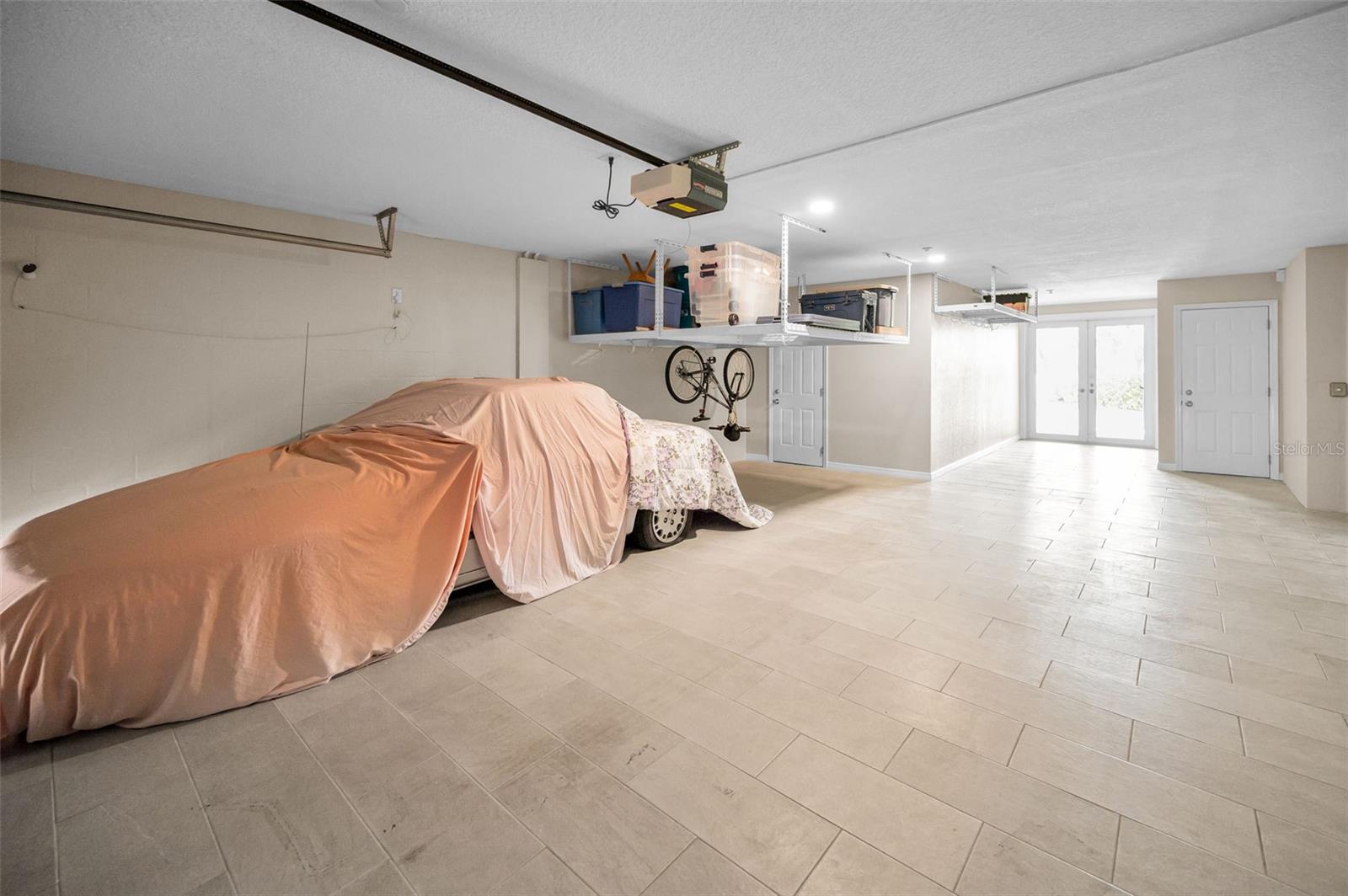 Huge garage! Tile on Floor! Wetbar is door to left and workshop is door to right. French doors lead to lanai.