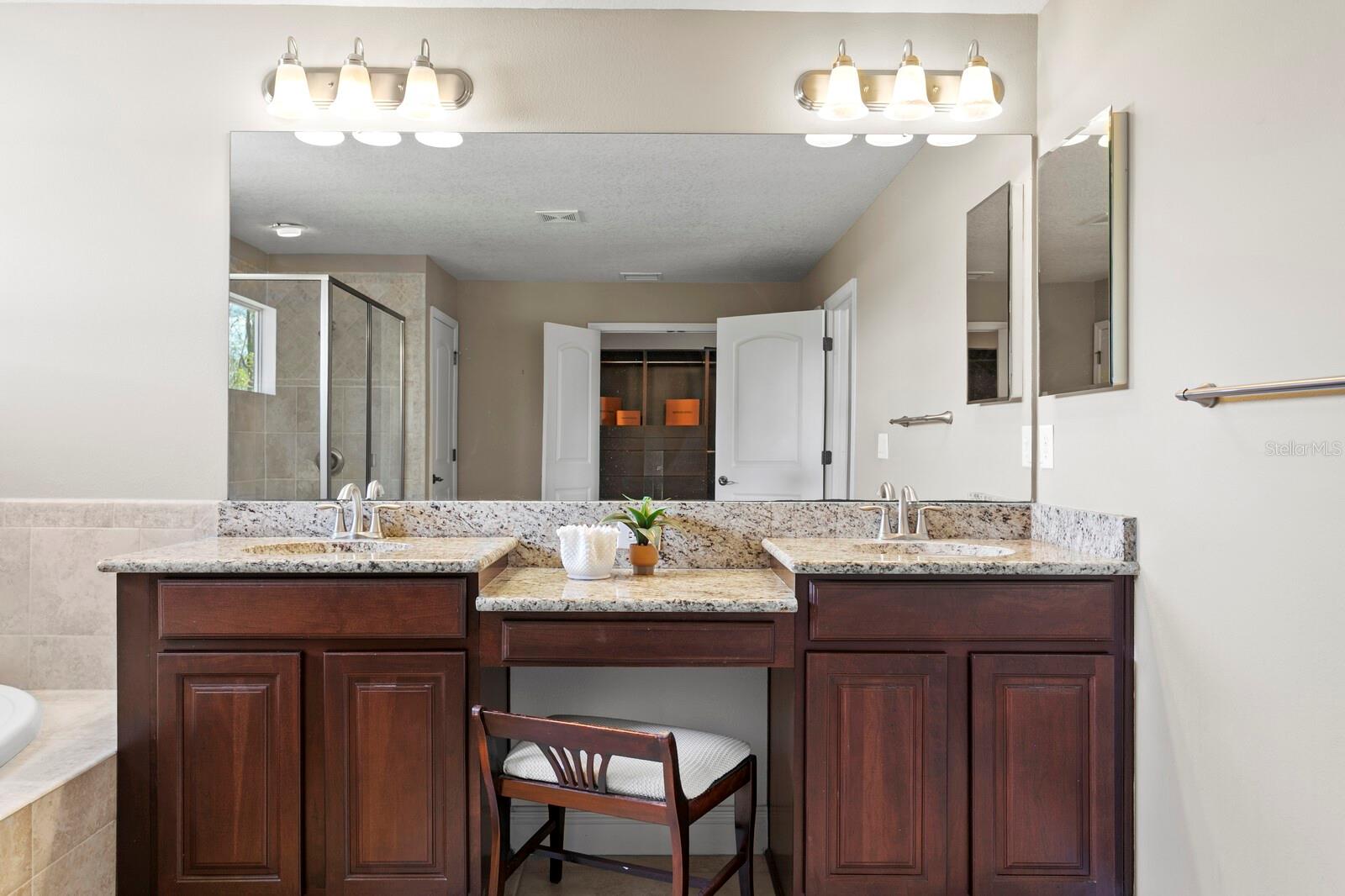 Dual vanities, granite counters and make-up station in the primary bath