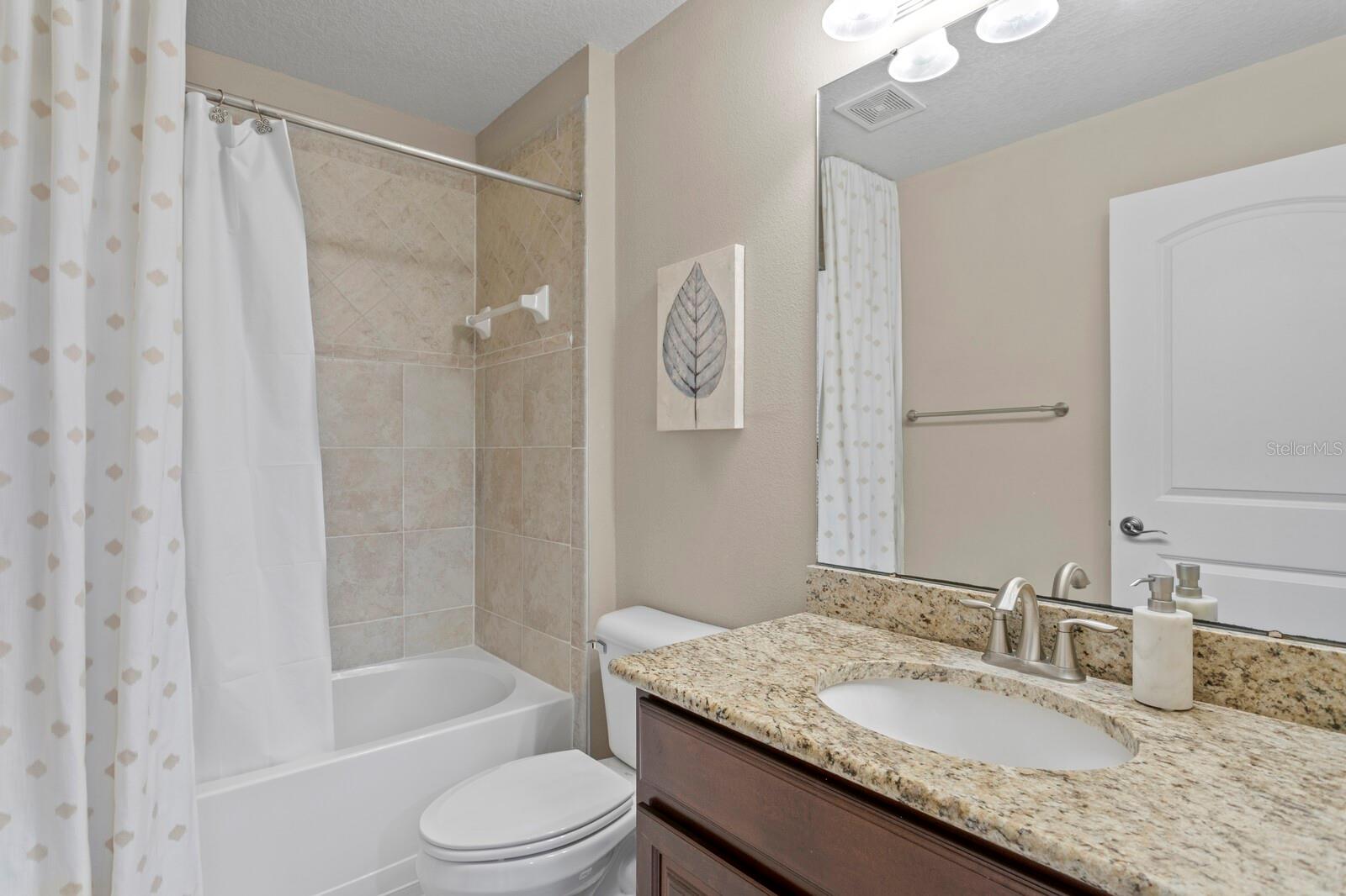Full bath with granite counters just outside the guest bedroom