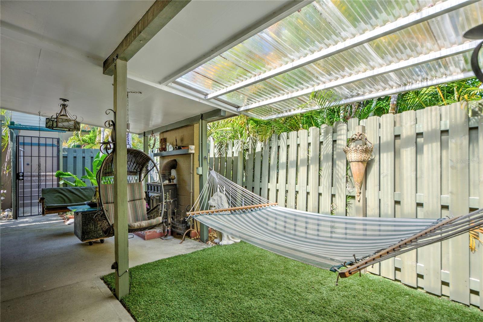 side porch area with swing and outdoor fireplace