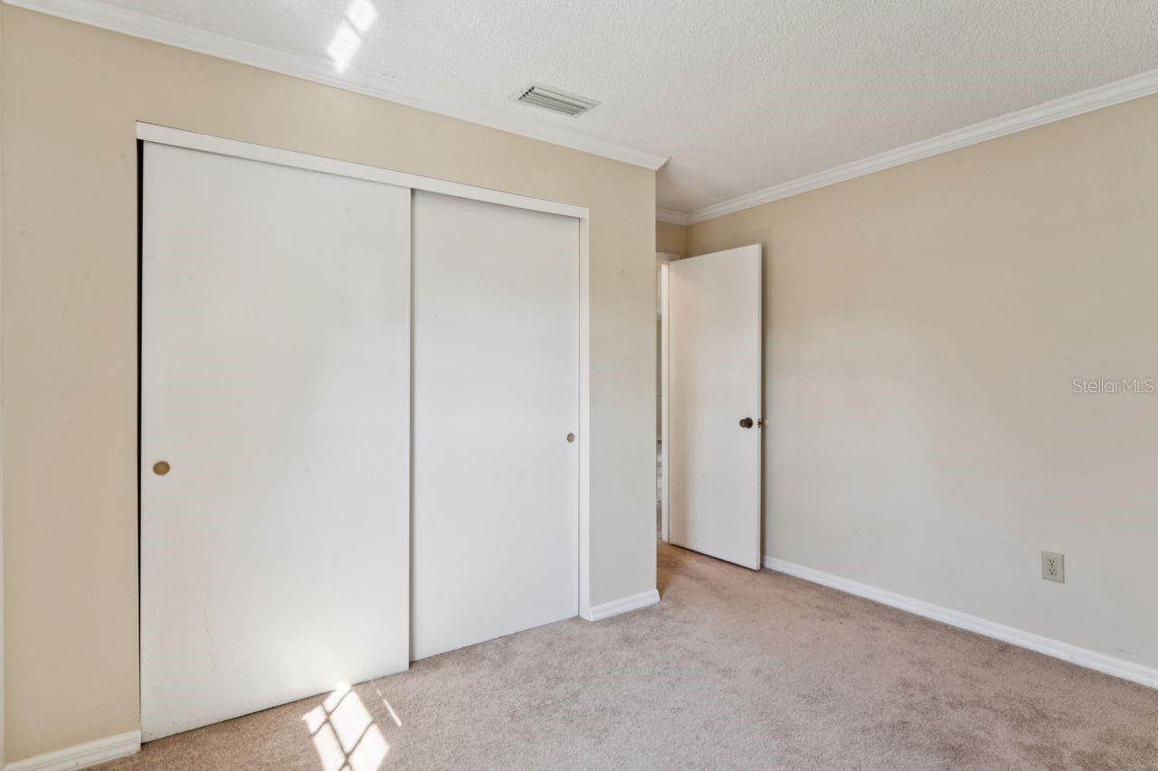 Double built-in closet with an entrance to the hallway and elegant crown molding.