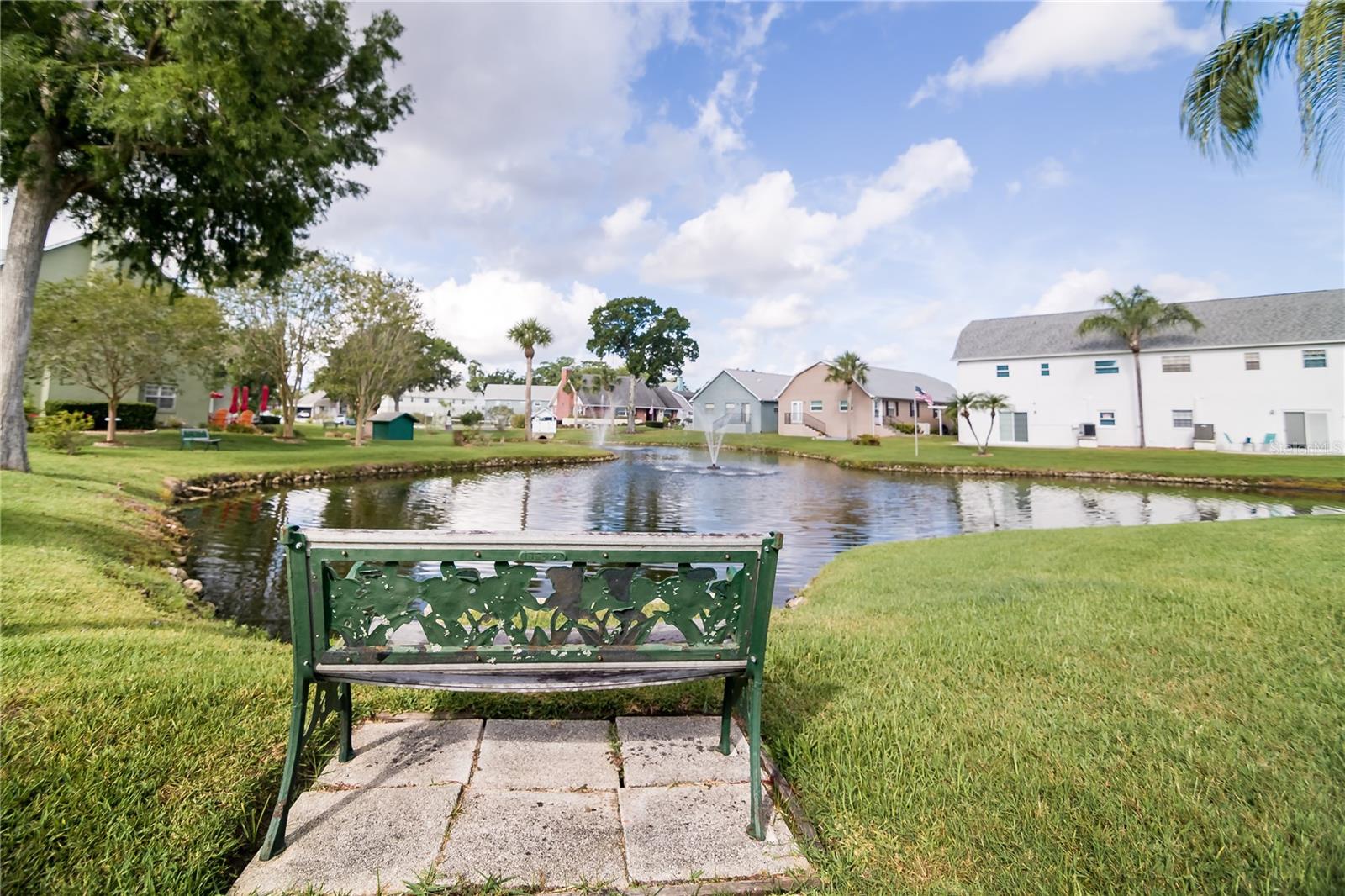 Park like view of the bench and pond.