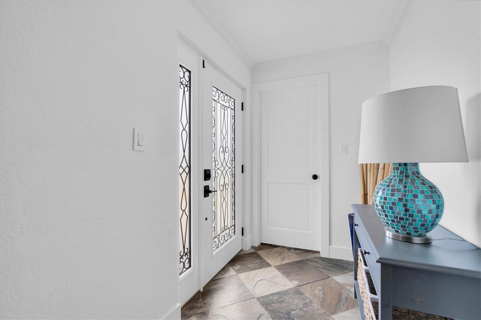 Beautiful entry with slate floors.  The laundry room is tucked behind that closed door.