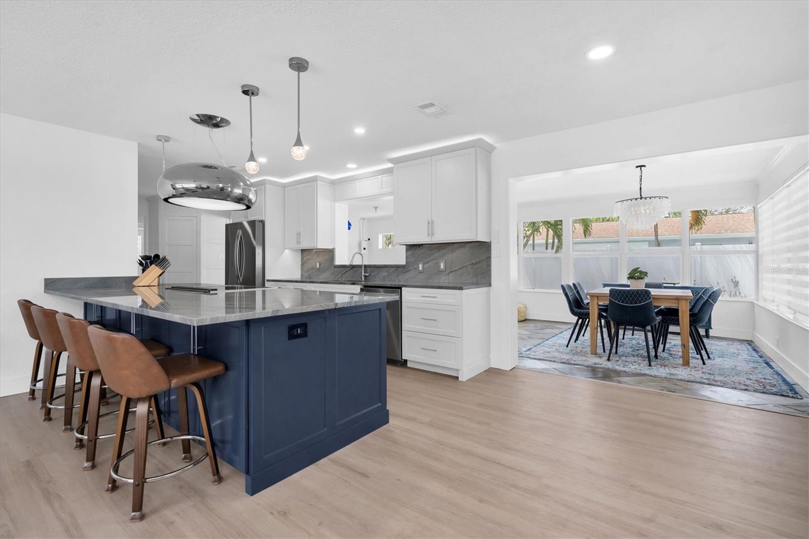 Completely renovated kitchen with custom cabinets, a huge quartzite island, custom pantry and dry bar.  To the right is the Florida room, it makes a beautiful dining area.