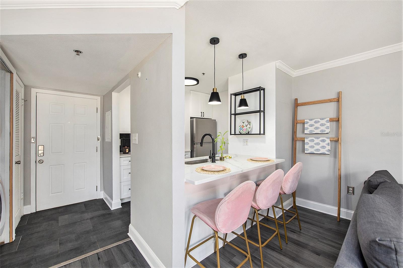 Viewof front door, laundry closet, kitchen and breakfast  bar