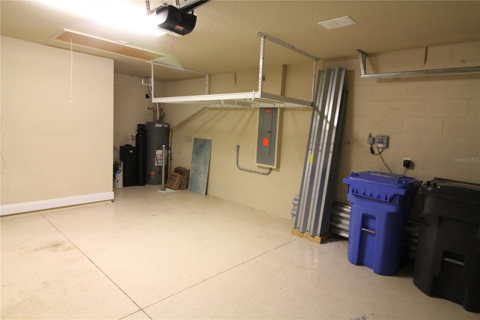 Garage with pulldown attic stairs, water softener, ceiling rack, nd hurricane shutters