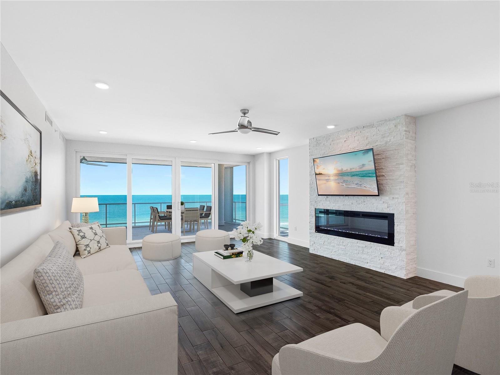 Gulf Front Living Room with stacked stone and electric fireplace - Virtually Staged