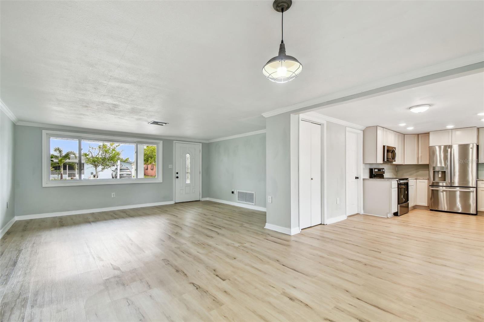Living/dining space looking to front of home with hallway to the left