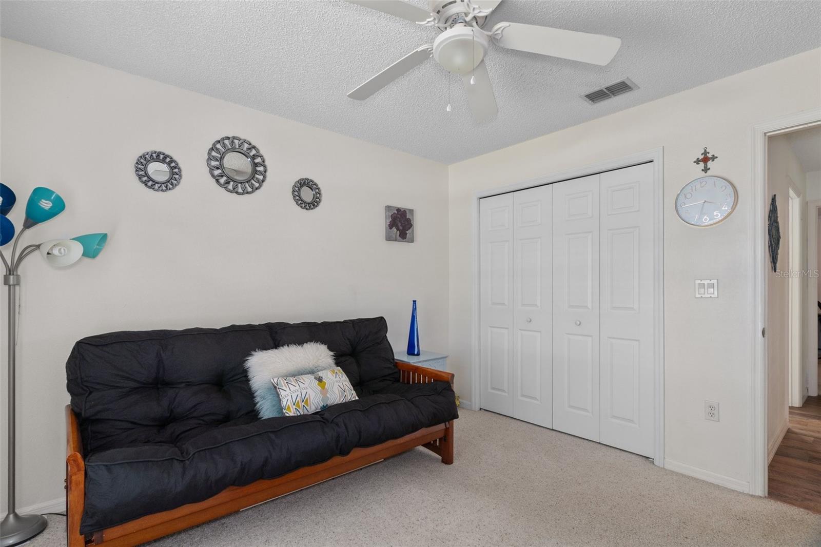 This bedroom has a large fan/light and a spacious closet