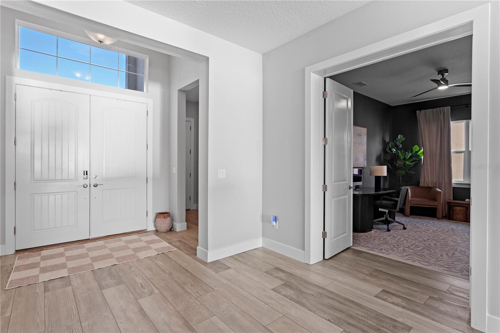Bright entryway with stylish flooring leading to a cozy home office!