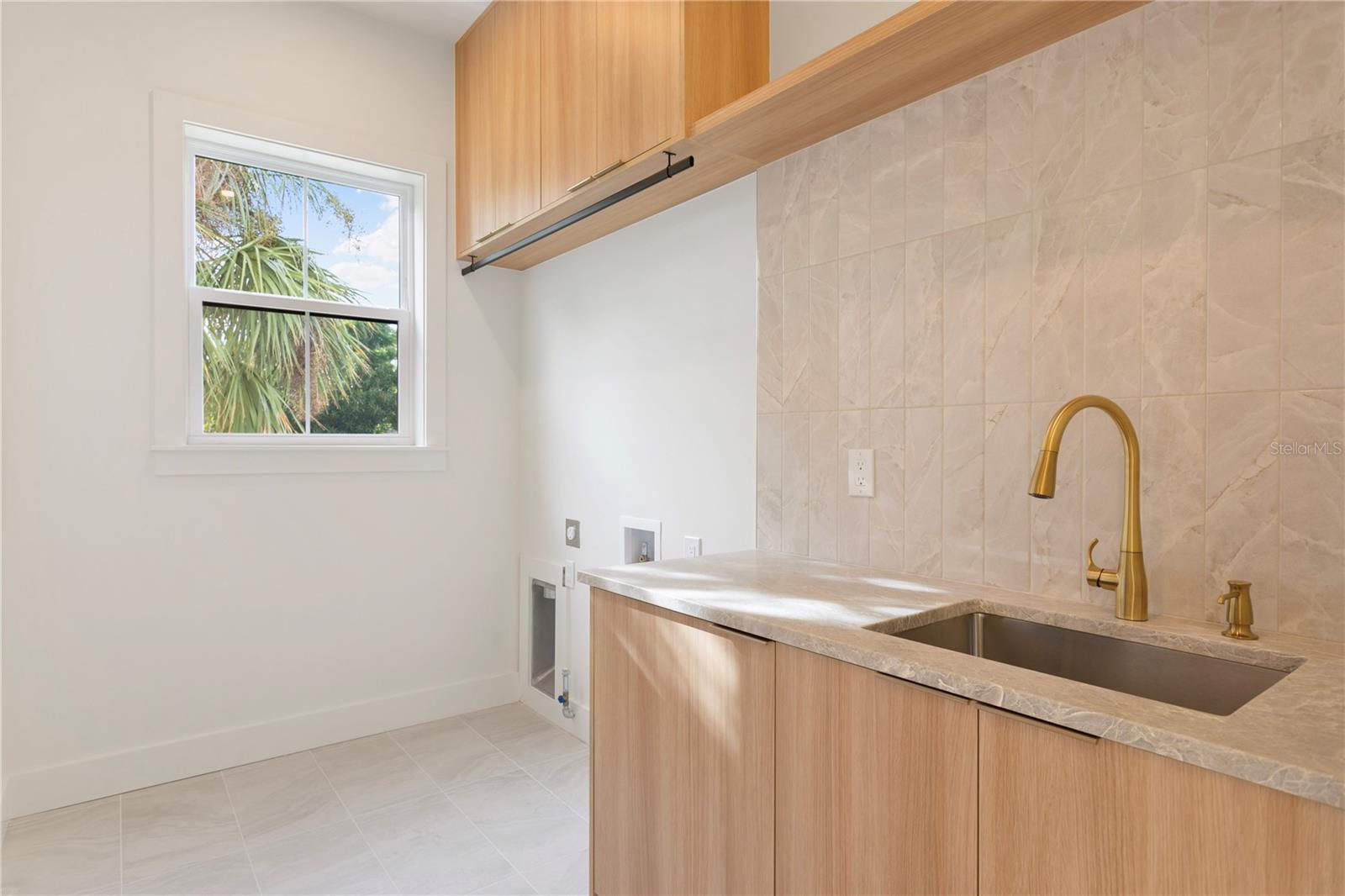 Upstairs Laundry room with ample storage, sink and beautiful cabinetry