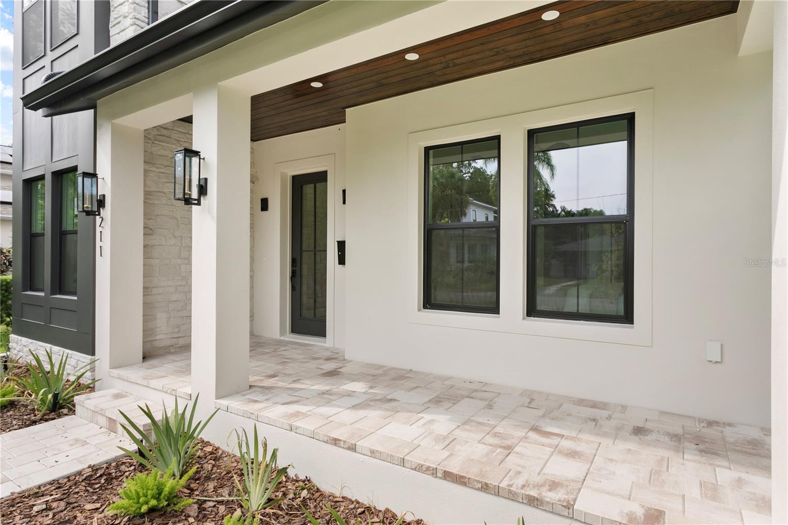 Paved front porch with stained wood ceilings.