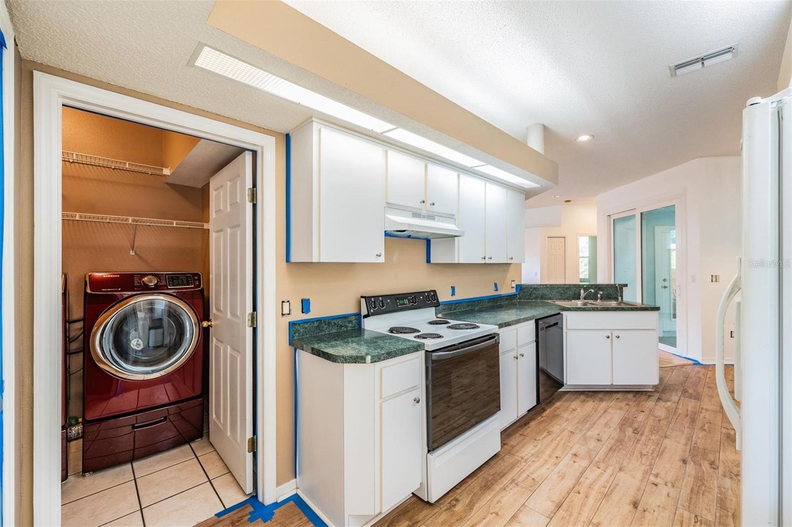 Owner is currently painting the interior. Laundry room to the left by garage service door.  Family room to the back left with 2 bedrooms and bathroom.