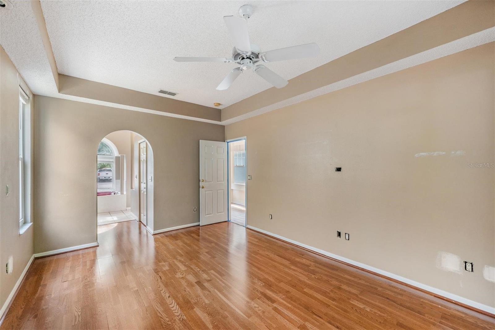 Primary Bedroom with hurricane resistance / double pane slider doors to lanai.  Reading lights in the ceiling trim.