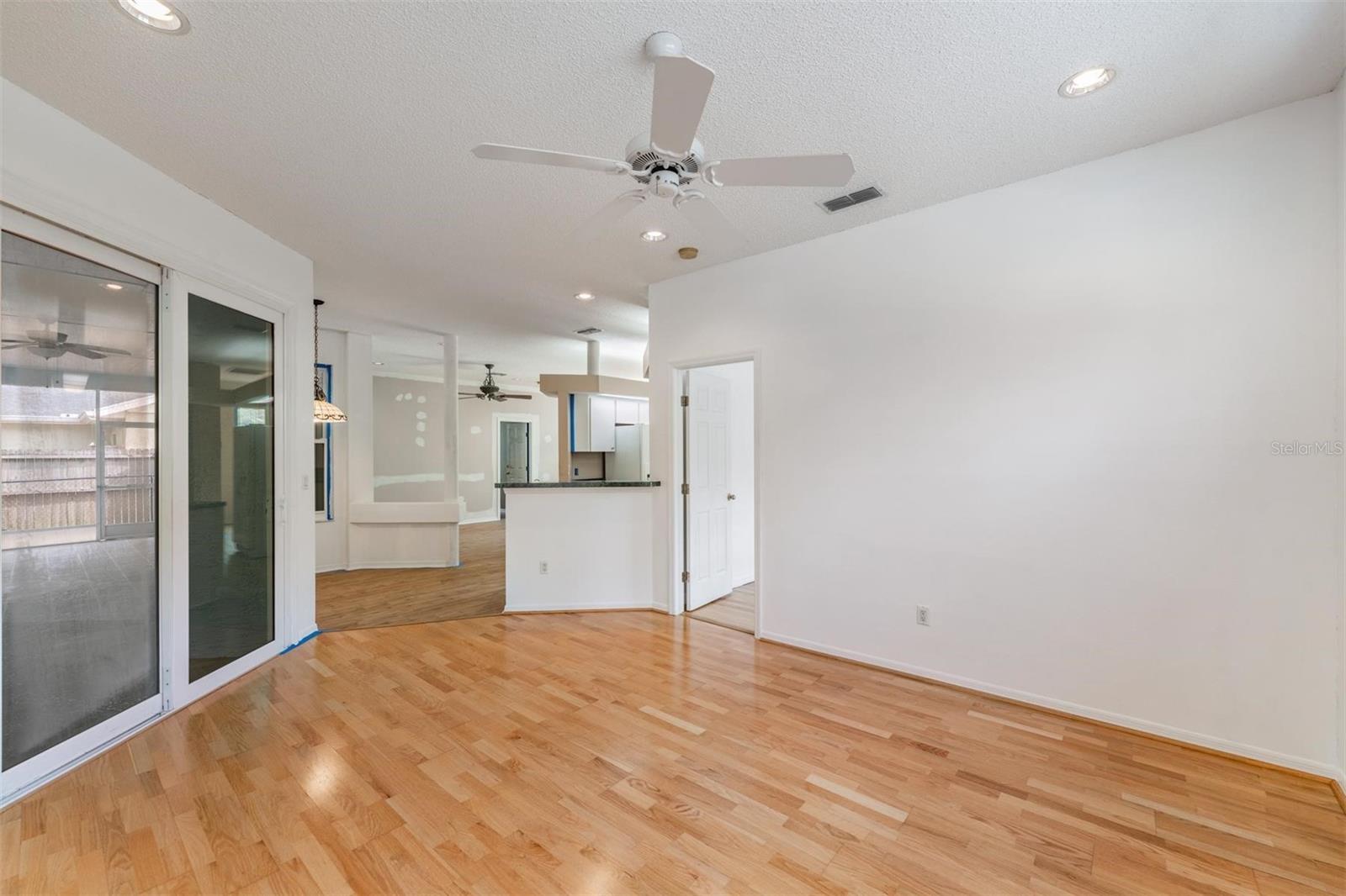 In Family room. Bedroom with fan and can lights. Bedroom 2 and bath is to the left.  Bedroom 3 is to the right. Kitchen is straight ahead.