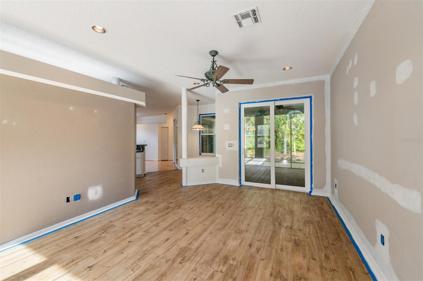 Living Room with Porcelin tile,  hurricane / double pane slider to screened lanai over looking water.  House never flooded. Breakfast nook to the left.