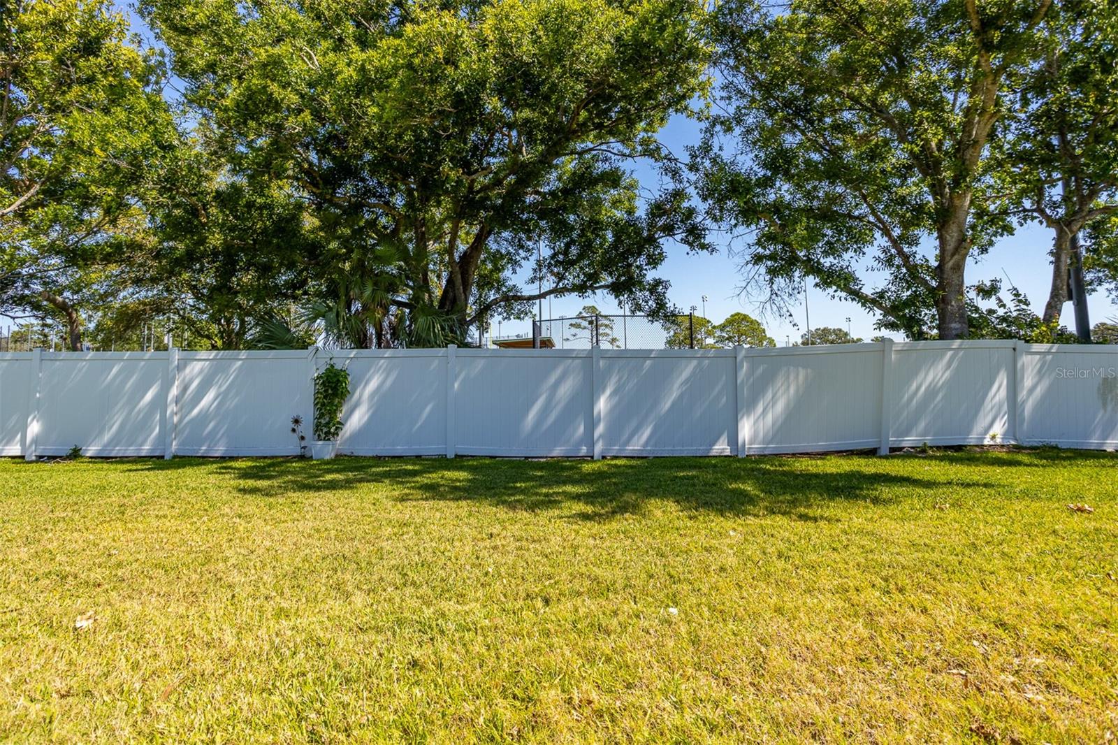 This is your back view behind the patio. A white vinyl fence and a sports complex. Lots of green space to throw a ball!