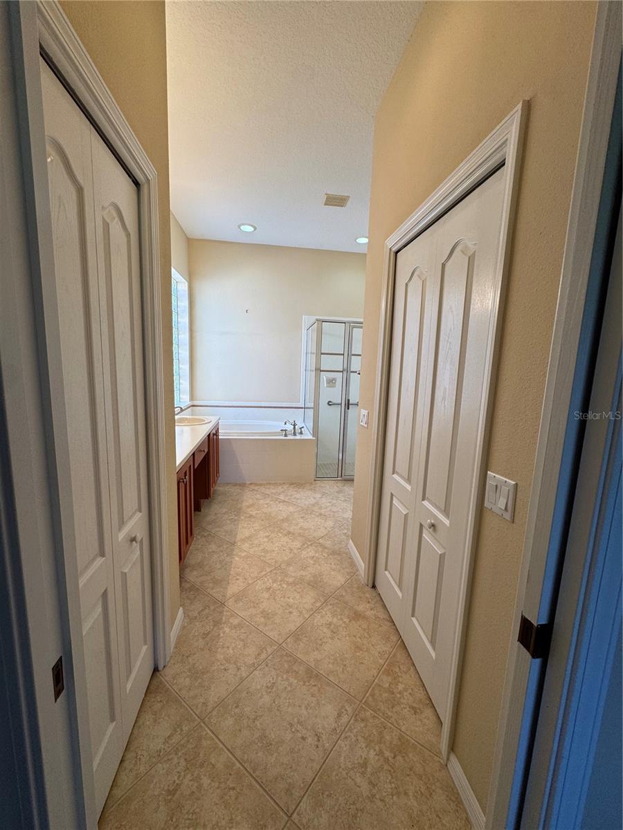 HIs & her closets lead to master bathroom