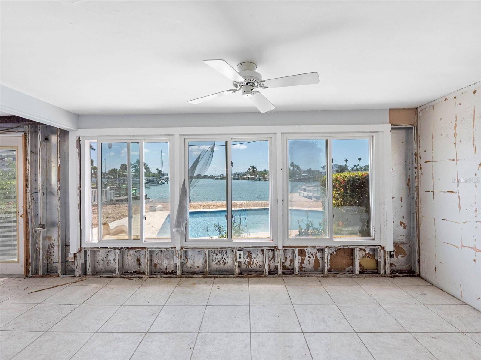 Sunroom with pool and water views.