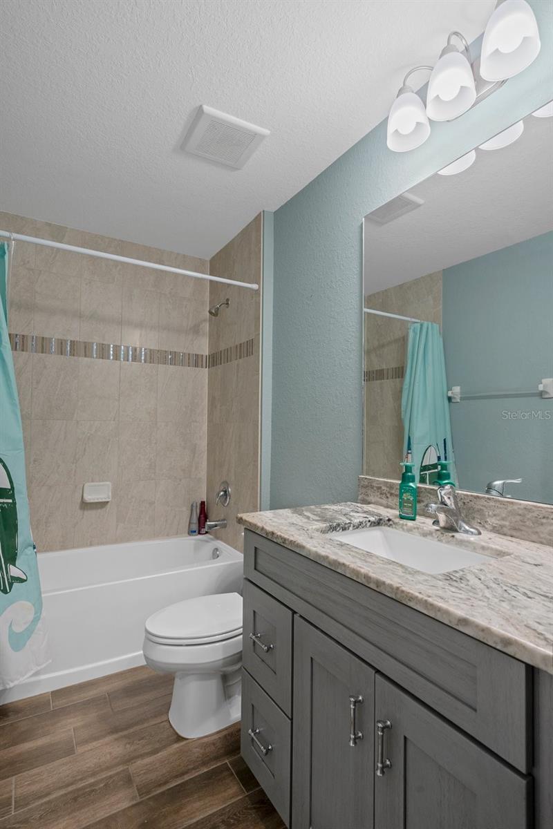The guest bathroom has a beautifully tiled tub/shower