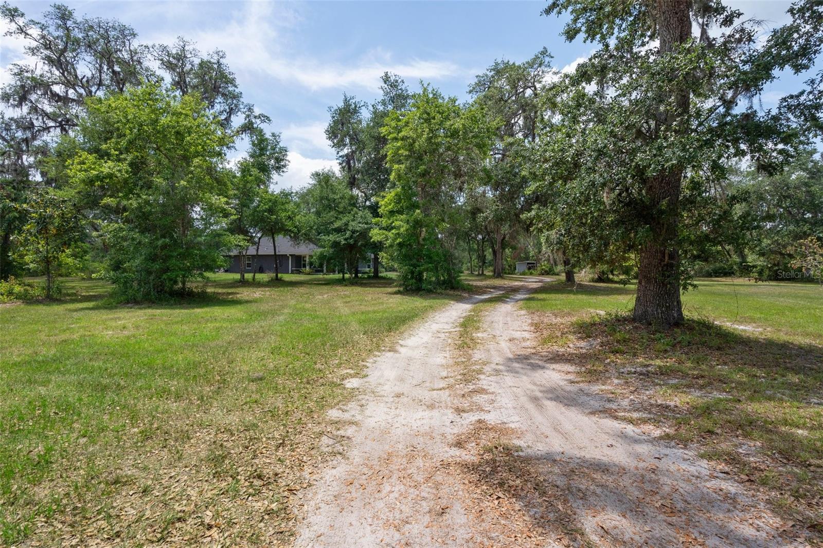 There is a long driveway leading to the home