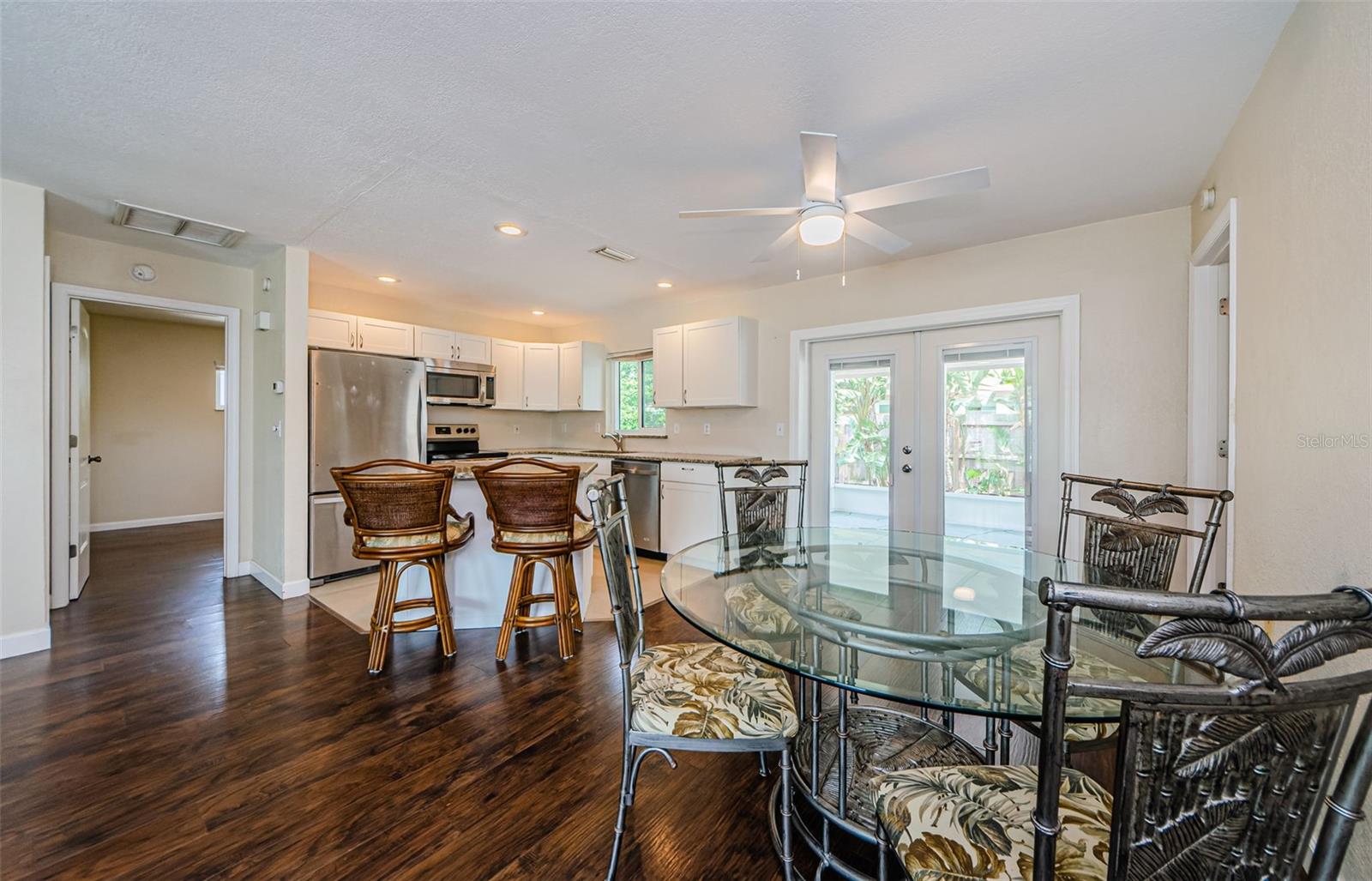 Double doors to back porch and view into bedroom 2.