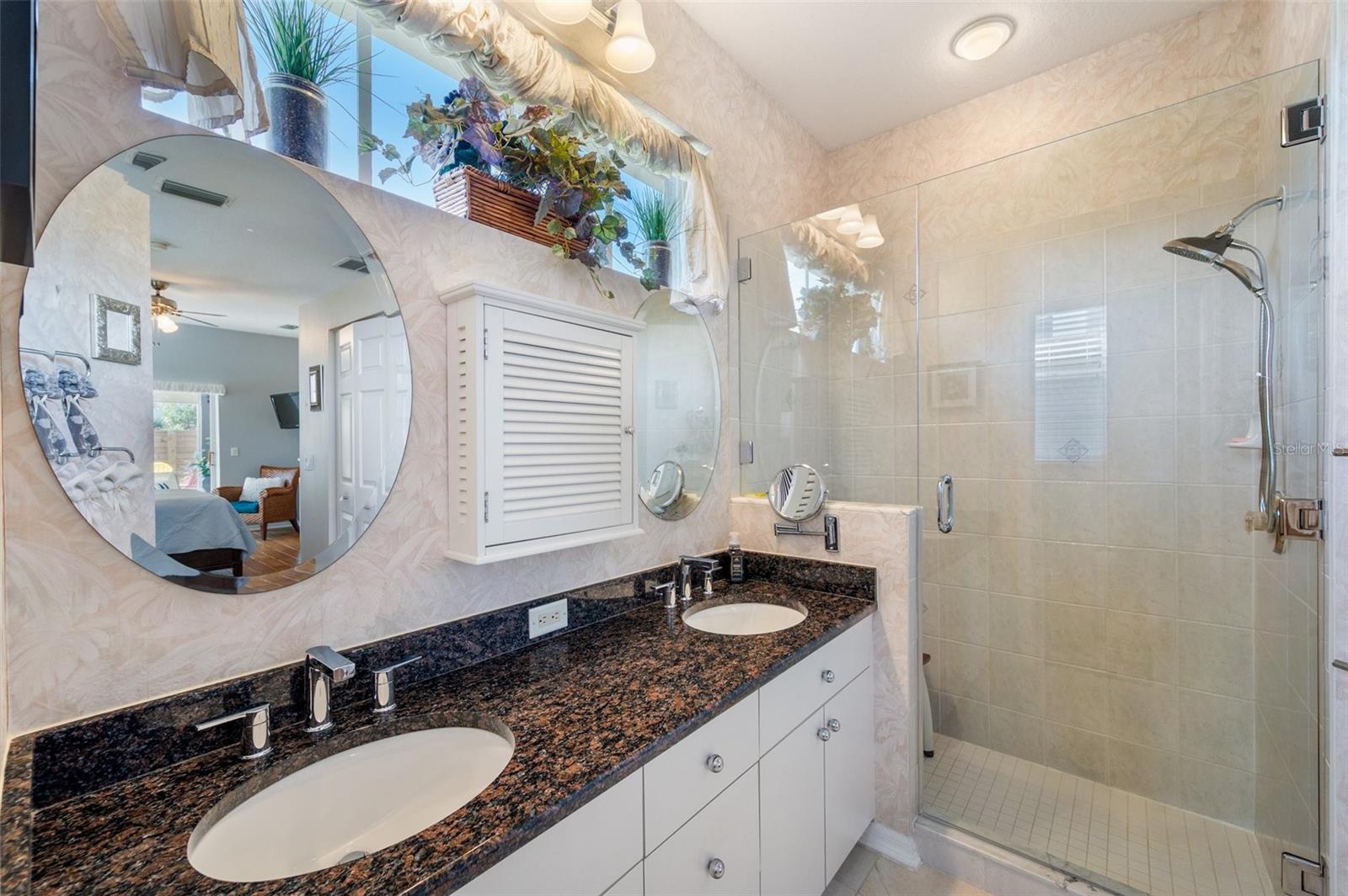 Primary bathroom with dual sinks and a walk in shower