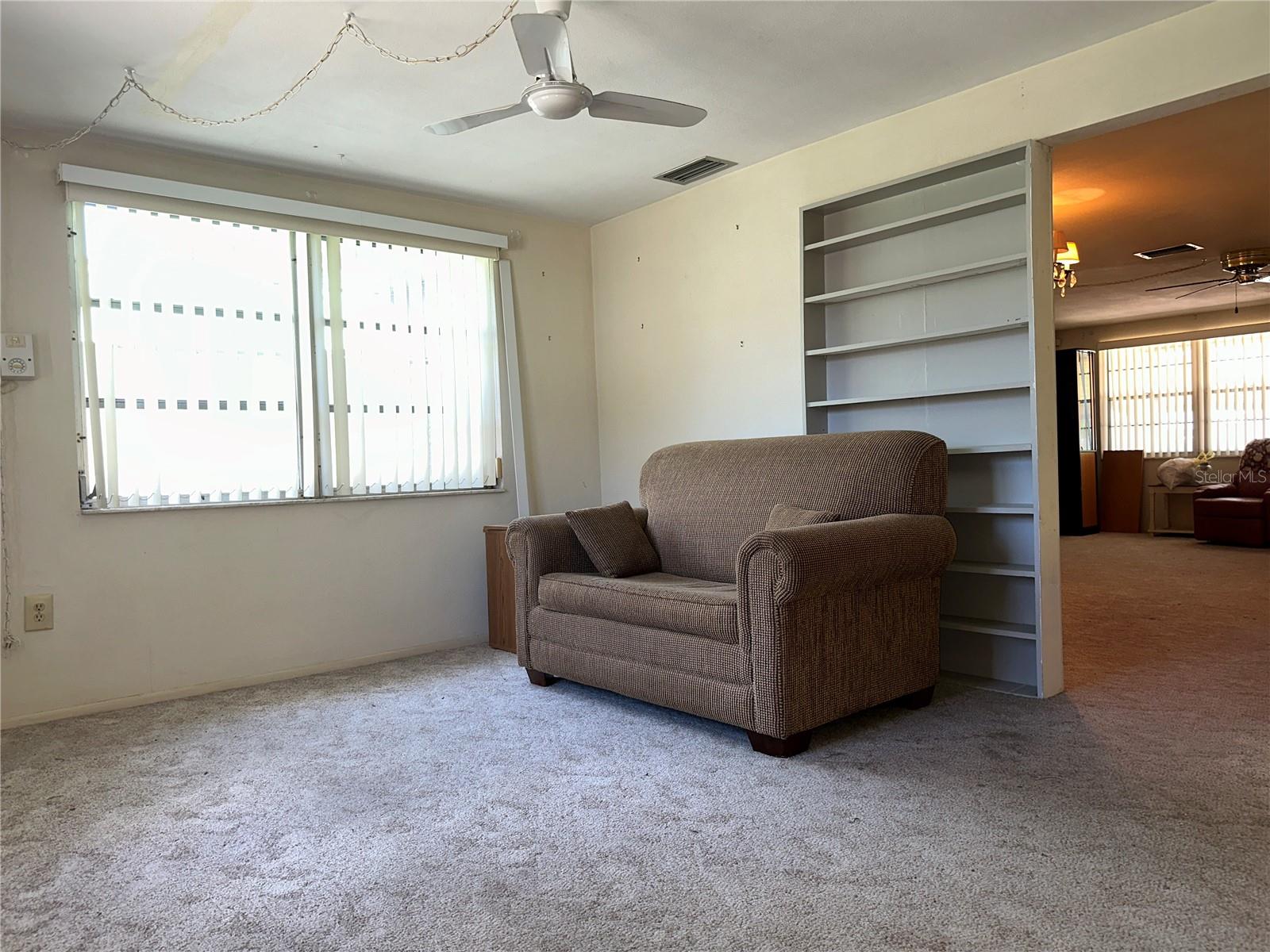 View of the family room looking back towards the entrance and built in shelves