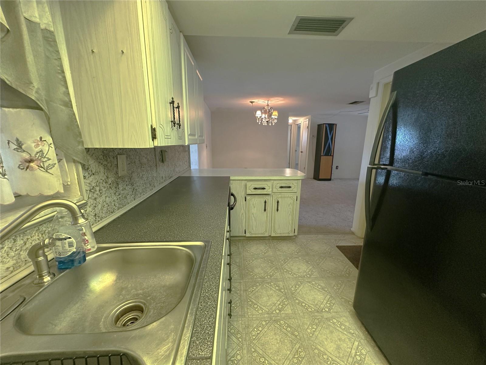 View of the kitchen looking back towards the breakfast bar area and dining room area in the backkground