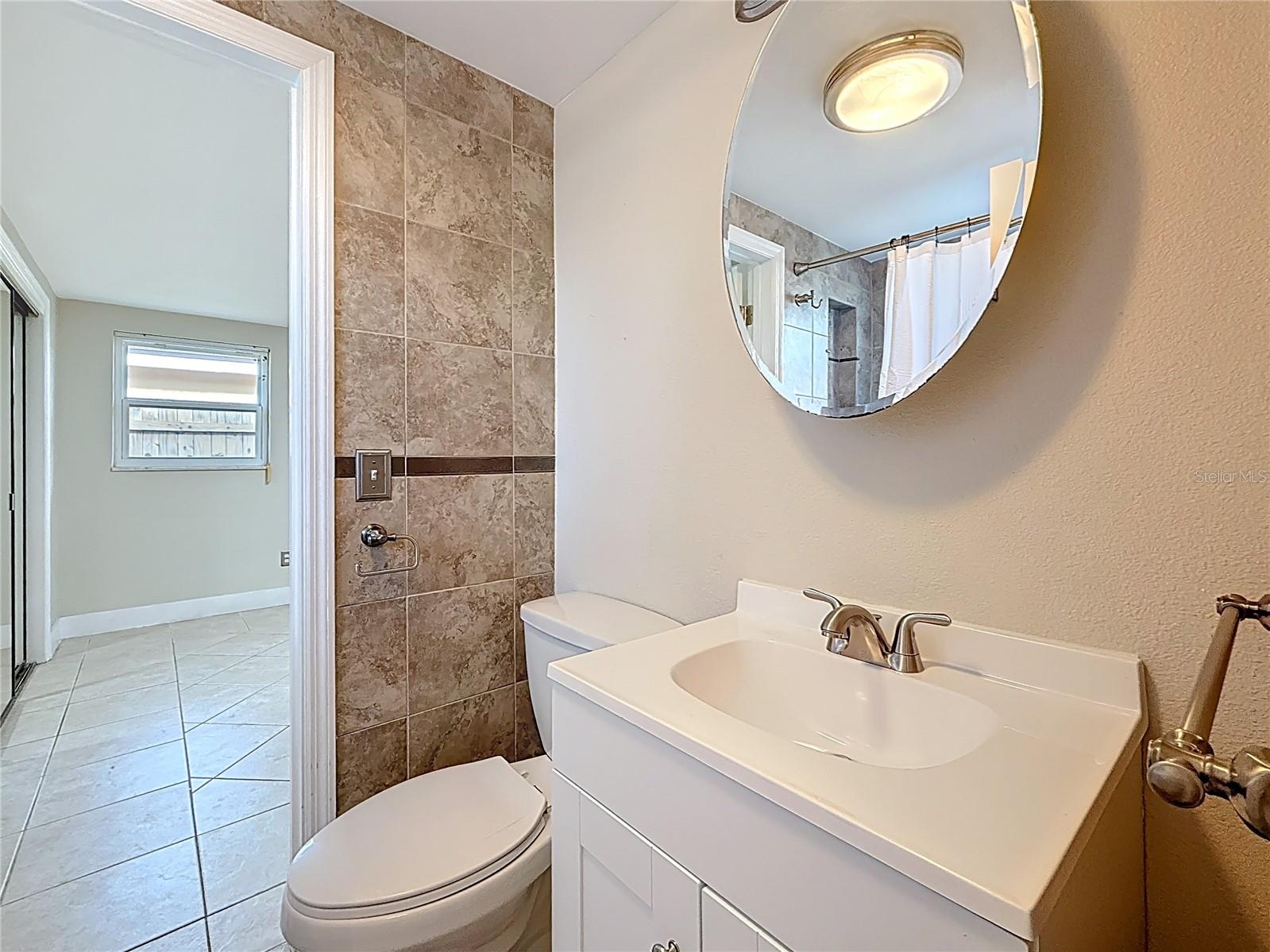 Full Bath and view into Primary Bedroom
