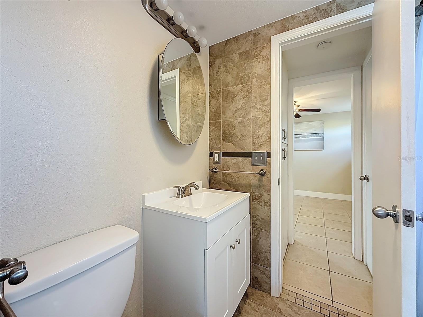 Full Bath and view into Secondary Bedroom
