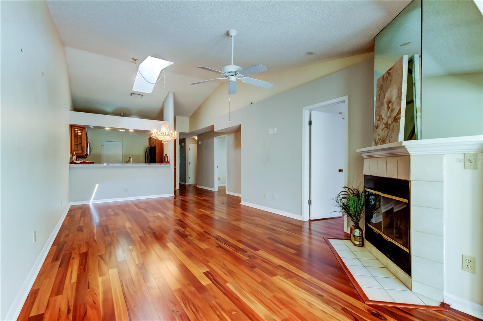 6. Great Room (12.9 x 23.3') w Living + Dining Area = Impressive w HIGH Ceilings, x2 Skylights, Solid Wood Flooring.. Fireplace!