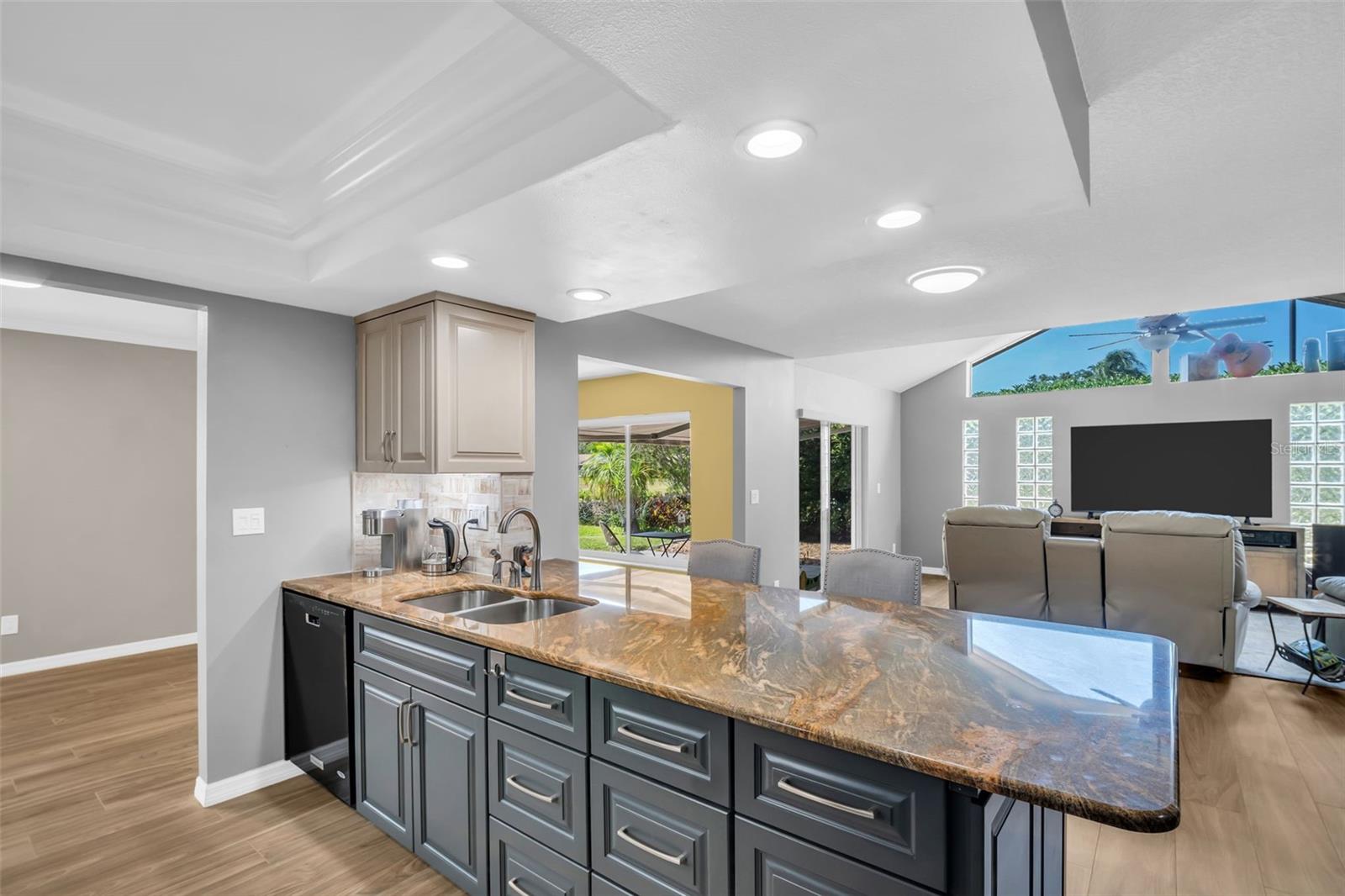 Kitchen opens to the beautiful addition with a vaulted ceiling and lighting.